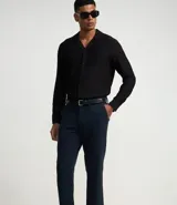 Pantalón de sastrería corte slim, color azul marino, con cintura elástica, trabillas para cinturón, cierre tradicional y bolsillos laterales.