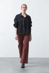 Remera de manga larga color beige, confeccionada en algodón, con escote en V y cartera corta de botones blancos.