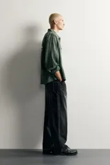 Pantalón jeans de corte relaxed fit, color celeste con efecto lavado, de estilo carpintero con bolsillos laterales y presillas de herramientas.
