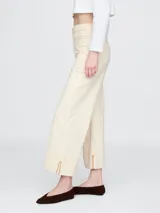 Jean de corte recto y tiro alto, con diseño tipo utility que incluye bolsillos frontales de parche y ruedo con dobladillo ancho. Presenta costuras a la vista en tono contrastante.