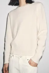 Jersey de punto de cuello redondo y manga larga, con acabados en rib en puños, cuello y bajo.