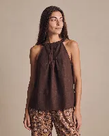 Blusa de lino marrón oscuro, con escote halter, pliegues delanteros y silueta amplia y fluida.