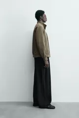 Cazadora azul marino de corte regular fit, confeccionada en tejido técnico repelente al agua. Presenta cuello subido, manga larga, bolsillos de vivo en cadera, bolsillo interior y acabados en rib en puños y bajo. Cierre frontal de cremallera oculta por solapa con botones a presión.