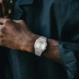 Reloj Casio de estilo vintage con diseño ana-digi, caja de 36mm y brazalete de acero inoxidable. Presenta una esfera plateada con manecillas analógicas y una pantalla digital inferior para funciones adicionales.