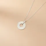Collar de plata 925 con cadena de eslabones finos y dije circular con textura estriada radial.