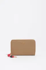 Billetera Bimba y Lola de cuero sintético color beige, con cierre perimetral y logo grabado en letras doradas. Incluye un tirador de cierre con cordón rojo y detalles de cuentas.