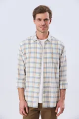 Camisa de manga larga de lino y algodón, con estampado a cuadros en tonos beige, blanco y celeste, cuello camisero y cierre frontal con botones.