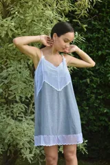 Camisón de algodón color beige con escote en V y ruedo decorados con puntilla gris. Presenta breteles finos y corte recto.
