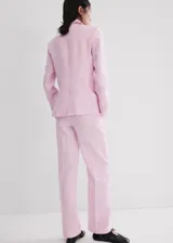 Pantalón de lino color rosado, de diseño recto y tiro medio, con trabillas, bolsillos laterales y cierre oculto.