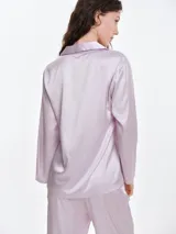 Camisa de dormir de satén con cuello solapa, cierre frontal con botones y mangas largas. Presenta un corte holgado y fluido.