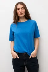 Remera blanca de manga corta raglán con detalle de vainillas, cuello redondo y corte clásico.