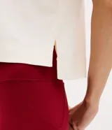 Remera polo deportiva de manga corta, confeccionada en poliamida y elastano. Presenta cuello polo con escote en V y un bordado temático de tenis con la inscripción 'Athletic Grace' en el pecho.