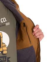 Chaqueta de lona color marrón con forro interior de sherpa gris, capucha ajustable con cordones, cierre frontal de cremallera, bolsillos laterales y bolsillo frontal con cierre en el pecho.