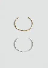 Pack de dos pulseras rígidas abiertas tipo brazalete de acero inoxidable, una en tono dorado y otra en tono plateado, con diseño minimalista y elegante.