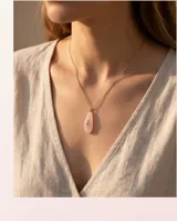Collar de acero con baño de oro, compuesto por una cadena fina y un dije en forma de lágrima de cuarzo rosa con una circonia central.