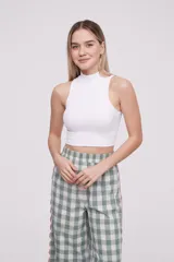 Top de punto acanalado color blanco, con cuello alto y diseño sin mangas, de corte ajustado al cuerpo.