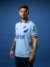 Camiseta de fútbol celeste con cuello y mangas con detalles en azul y rojo. Incluye logo de Umbro, escudo del Club Nacional de Football y sponsor Antel.