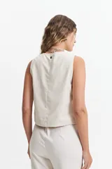 Chaleco corto color marrón topo, con escote en V asimétrico y cierre cruzado con botones.