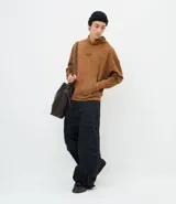 Pantalón cargo de corte mega baggy, color negro, confeccionado en sarga de algodón. Presenta múltiples bolsillos funcionales y un diseño versátil que permite transformar la prenda en bermuda mediante un sistema de ajuste en las piernas.