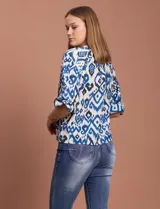 Blusa de gasa estampada en tonos azules y negros, marca Sioni. Tiene cuello a la base con escote en V, abertura central con botones y mangas tres cuartos fruncidas.