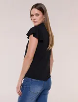 Camisa de seda fría blanca con cuello solapa, escote en V y cierre frontal de botones. Cuenta con mangas cortas con volados.