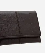 Billetera pequeña tipo sobre, color marrón oscuro con textura efecto cocodrilo. Cuenta con cierre mediante botón metálico y compartimentos internos organizados para tarjetas.