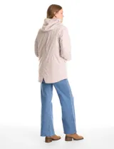 Campera 3 en 1 de color beige, con sistema de capas desmontables. La capa exterior es de tejido técnico resistente al viento y lluvia ligera, con capucha fija, cierre frontal con solapa, bolsillos de parche y ajuste elástico interno en la cintura. Incluye una campera interior capitoneada ultraliviana que puede usarse de forma independiente.