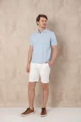 Remera tipo chomba de piqué, color azul marino jaspeado, con cuello y tapeta de dos botones. Presenta un pequeño logo bordado en color rosado en el pecho.