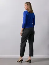 Cardigan blanco de tejido fino con abertura central y botones.