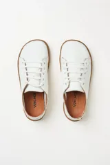 Zapatillas de cuero blanco con diseño minimalista, cordones al tono y suela de goma color suela con costura vista.