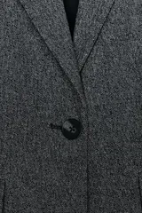 Blazer recta gris con hombreras, cuello solapa, manga larga, bolsillos delanteros con solapa y cierre frontal con un botón.