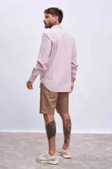 Camisa de manga larga color rosa claro con botones. Corte clásico.