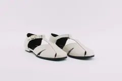 Zapatos bajos color verde oliva de cuero, con tira sobre el empeine y hebilla dorada.