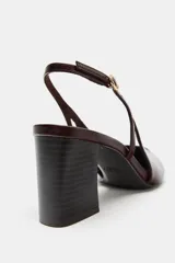 Zapato destalonado de tacón ancho, con tira trasera ajustable mediante hebilla metálica y diseño de punta fina.