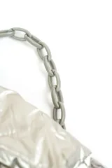 Cartera acolchada negra de material sintético con efecto brillante y costuras en rombos. Cuenta con solapa frontal y una correa corta de cadena gruesa de eslabones plásticos negros.