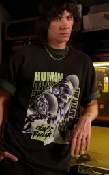 Remera de algodón premium con calce oversize, cuello redondo y mangas cortas. Presenta un estampado gráfico frontal con temática de Daft Punk en tonos verdes y negros.