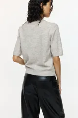 Remera corta en punto suave con cuello redondo acanalado, mangas cortas y bajo recto. Puños y bajo en punto acanalado.