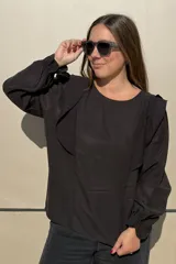 Blusa de algodón color bordó, con diseño de volados en los hombros, mangas largas con puños elásticos y corte holgado.