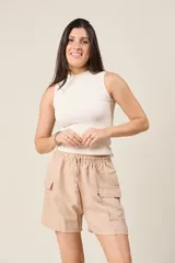 Short color beige con cintura elástica ajustable con cordón, bolsillos laterales y bolsillos cargo con solapa en los muslos.