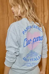 Sudadera de cuello redondo y manga larga, confeccionada en tejido gris melange. Presenta un diseño estampado en el pecho con un corazón y la frase 'Pasta fresca Ciao cara! Dell'Italia'. Cuenta con puños y ruedo acanalados.