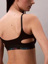 Corpiño deportivo Calvin Klein de algodón modal, color negro, con copas suaves sin relleno, tirantes ajustables y banda elástica inferior con logo multicolor en degradé.