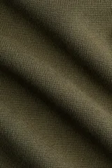 Top de punto suave verde militar, de corte ceñido, cuello alto y mangas cortas con aberturas laterales en las sisas.