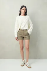 Short de tiro medio con calce al cuerpo y dobladillos en el ruedo. Presenta cierre frontal con botón y bolsillos laterales.