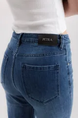 Pantalón de jean azul de corte acampanado, tiro alto y cinco bolsillos.