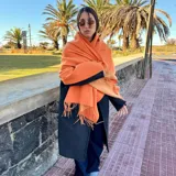 Bufanda de lana color naranja con flecos en los extremos.