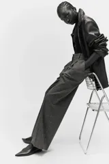 Pantalón sastrero gris oscuro con estampado a cuadros, pinzas, cierre oculto, bolsillos al bies y piernas amplias con pliegues.