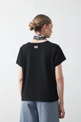 Remera básica de manga corta en color blanco, con cuello redondo y detalle de pliegues sutiles en los hombros.