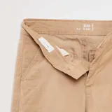 Pantalón chino color beige, corte slim fit, con bolsillos laterales y traseros.