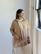Sweater de punto color arena con diseño de capas que incluye una camisa inferior y un pañuelo a juego, ambos con estampado animal print en tonos tierra.