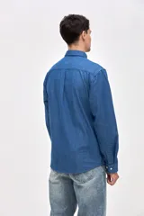 Camisa de corte regular fit confeccionada en algodón, con cuello solapa clásico, cierre frontal de botones y dos bolsillos frontales en el pecho.